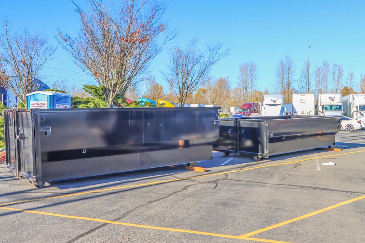 Professional dumpster rental service with roll-off container on residential driveway in Whitman